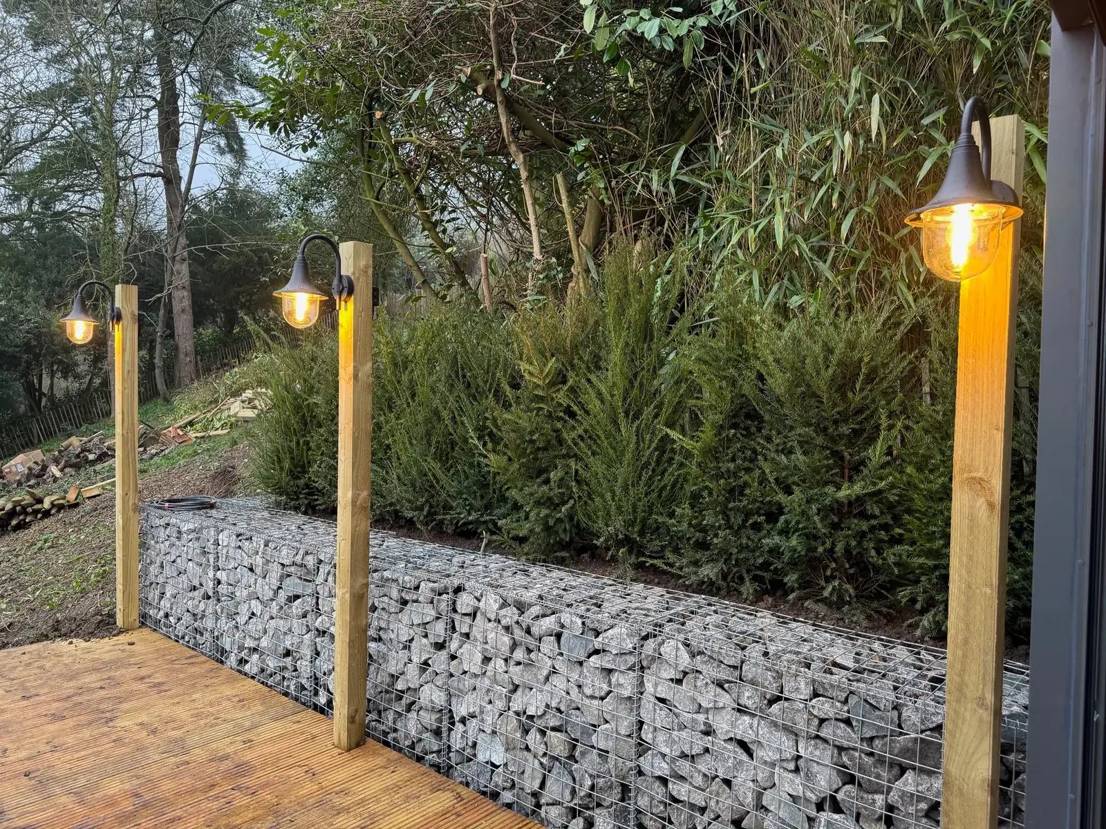 Outdoor garden lighting installed on timber posts along decking area