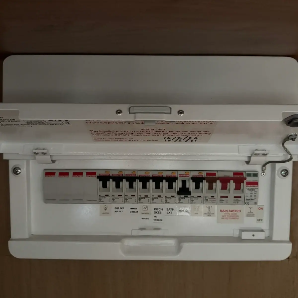 Modern consumer unit installed inside cupboard with labelled circuits